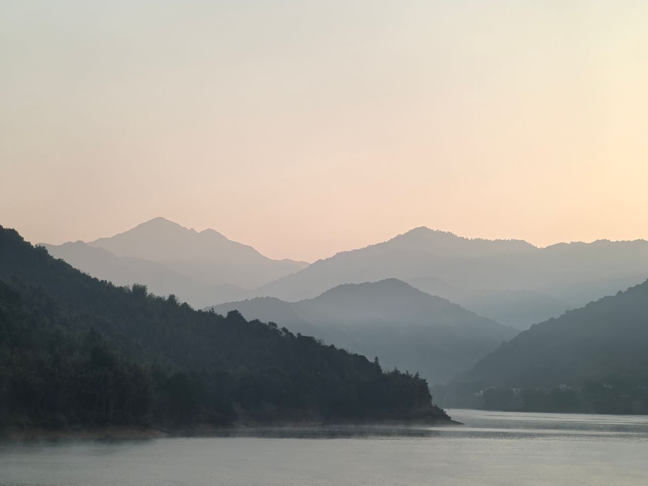 The Art of Drawing Readers In: Your attractive post title goes here Peaceful mountain scenery with mist and soft sunrise light over a calm lake.
