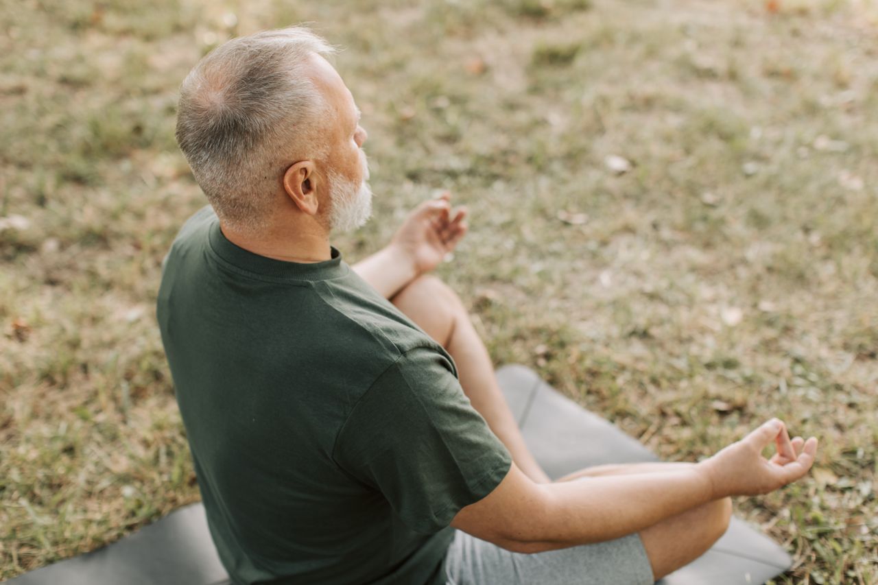 Mastering the First Impression: Your intriguing post title goes here Senior man practicing yoga in a serene outdoor setting, promoting wellness and mindfulness.